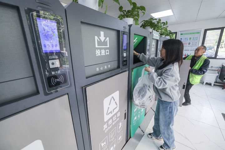 2024年4月10日，在浙江省湖州市吳興區(qū)飛英街道新華府小區(qū)內(nèi)，居民在垃圾分類智能系統(tǒng)的指導下進行垃圾分類投放，居民的投放情況將實時匯總到智慧服務(wù)平臺，會有相應(yīng)的積分獎勵。新華社記者 徐昱 攝