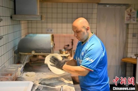 近日，韋榮耀在自家披薩小店內(nèi)忙活。俞靖 攝