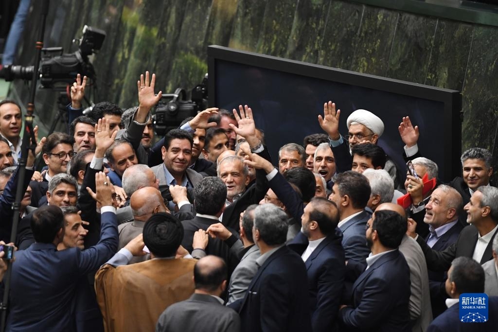 7月30日，在伊朗德黑蘭的伊朗議會(huì)，佩澤希齊揚(yáng)（中）離開(kāi)總統(tǒng)就職典禮現(xiàn)場(chǎng)時(shí)揮手致意。新華社記者 沙達(dá)提 攝