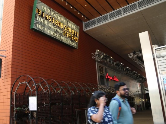 2023年5月29日，人們經(jīng)過美國紐約曼哈頓的“國債鐘”。“國債鐘”是一個大型計數(shù)器，它實時更新美國的公共債務(wù)總額，并顯示出每個美國家庭所要負(fù)擔(dān)的數(shù)額。 新華社記者劉亞南攝