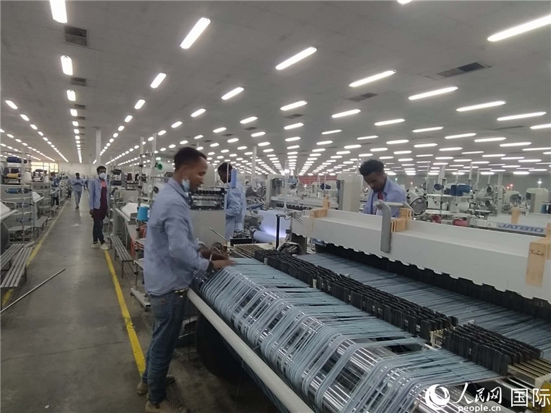 無(wú)錫金茂埃塞面料廠車間內(nèi)，當(dāng)?shù)毓と苏谝唤z不茍地作業(yè)。人民網(wǎng)記者 黃培昭攝