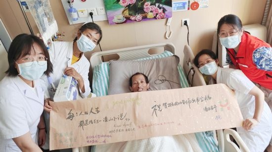 7月26日，海淀醫(yī)院安寧療護(hù)科醫(yī)護(hù)團(tuán)隊為朱銳送來一條寫滿祝福的橫幅。（受訪者供圖）