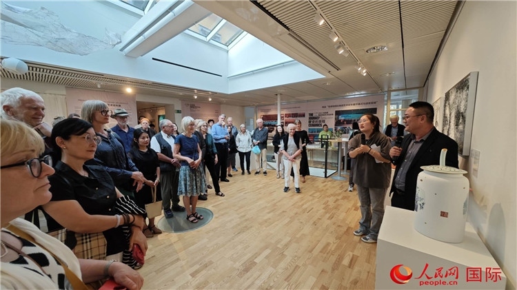 參展人、景德鎮(zhèn)陶瓷大學(xué)美術(shù)學(xué)院副院長(zhǎng)邵長(zhǎng)宗（右一）向來(lái)賓介紹參展作品。人民網(wǎng)記者 殷淼攝