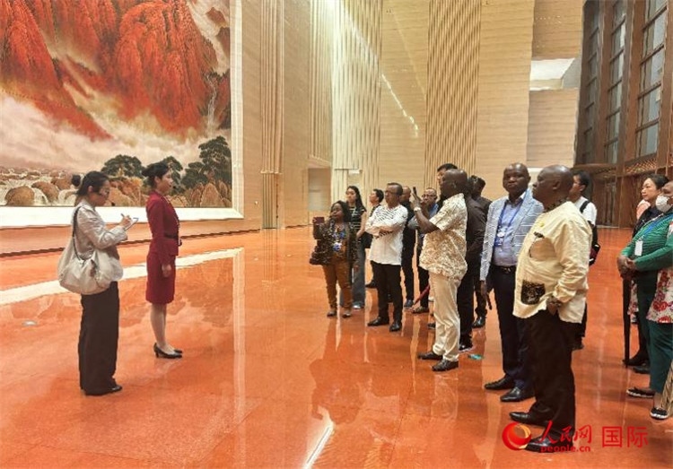 代表團(tuán)在入口處聽取講解。人民網(wǎng) 曹欣悅攝