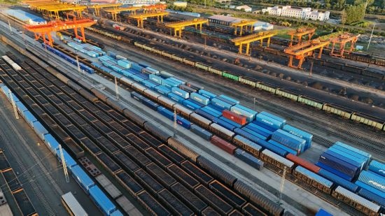 這是2024年8月14日在黑龍江綏芬河鐵路口岸集裝箱換裝場(chǎng)拍攝的集裝箱換裝作業(yè)現(xiàn)場(chǎng)（無(wú)人機(jī)照片）。今年前七個(gè)月，綏芬河鐵路口岸開(kāi)行中歐班列573列，運(yùn)量達(dá)55246標(biāo)箱，同比分別增長(zhǎng)23%和18%，班列數(shù)量持續(xù)保持高位運(yùn)行。