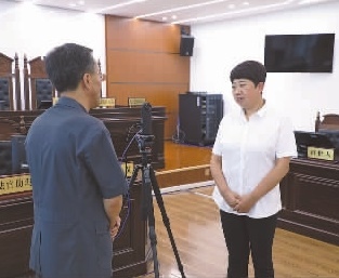 圖為全國(guó)人大代表玉明姬（右）詳細(xì)了解環(huán)境資源審判工作情況。劉思妤 攝