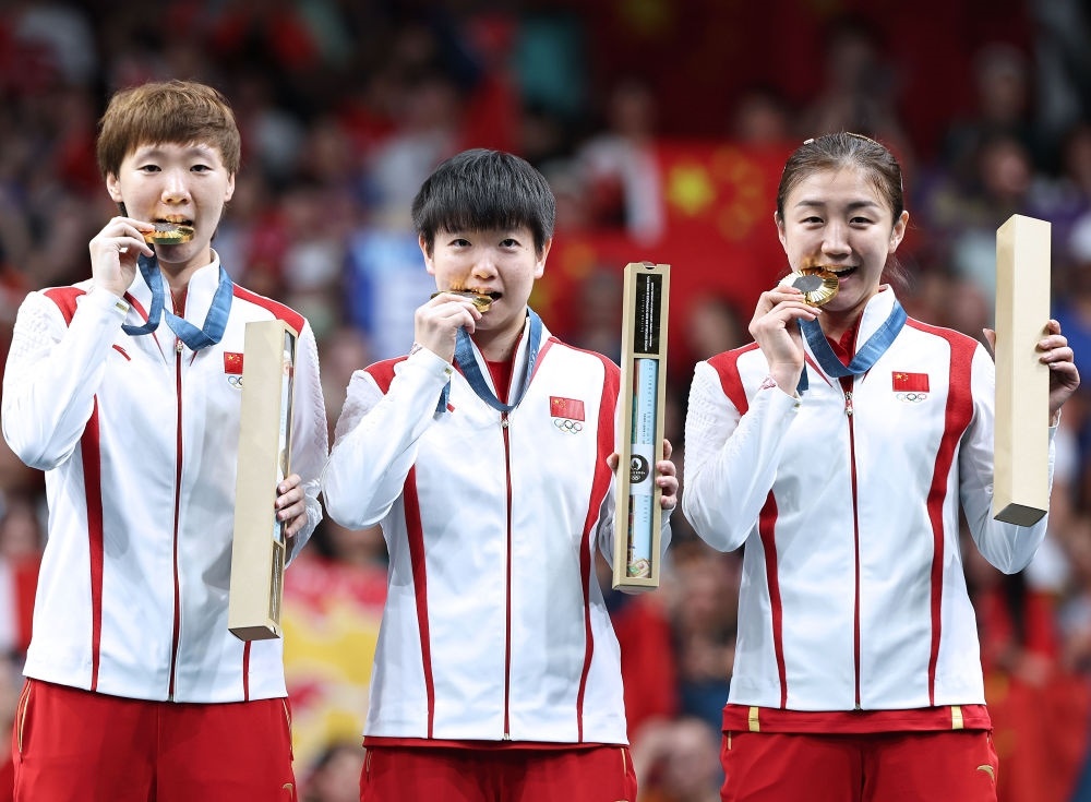 冠軍中國隊(duì)選手王曼昱、孫穎莎、陳夢（從左至右）在巴黎奧運(yùn)會(huì)乒乓球女子團(tuán)體頒獎(jiǎng)儀式上（2024年8月10日攝）。新華社記者 王東震 攝
