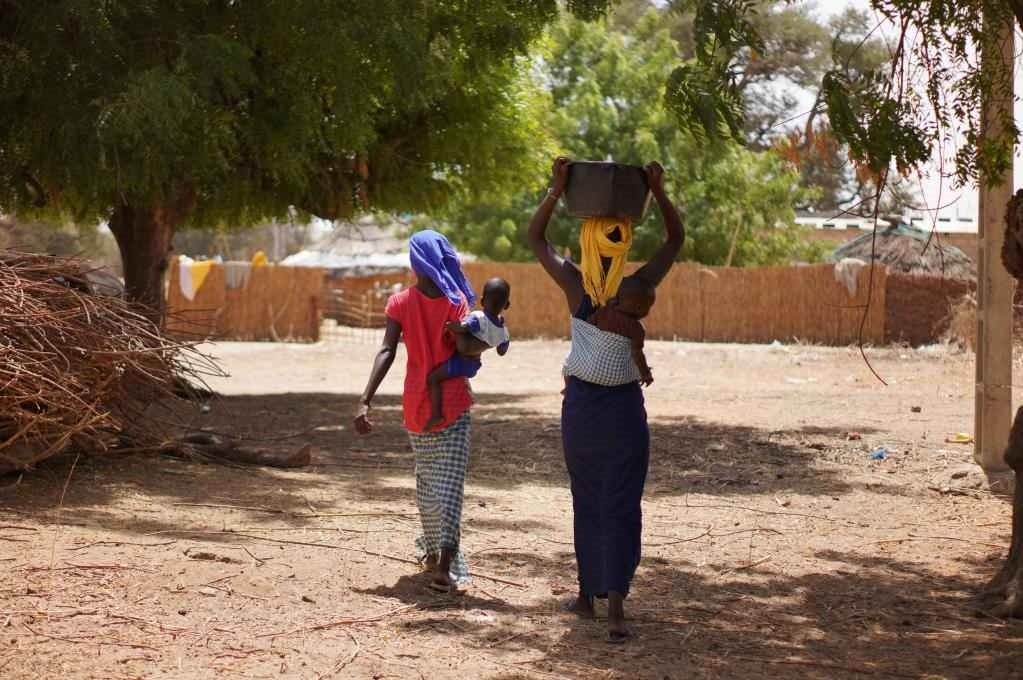 2023年3月20日，在塞內(nèi)加爾久爾貝勒區(qū)的泰內(nèi)富勒村，村民將取到的水運回家。新華社記者 王子正 攝