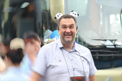 參訪熊貓谷前，塞爾維亞“一帶一路”研究所所長博揚·拉利奇戴上熊貓頭飾。（李佩藺 攝）