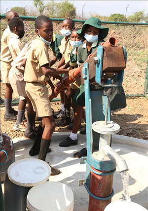 △2021年11月，在津巴布韋南馬塔貝萊蘭省省會關(guān)達(dá)的塞農(nóng)多小學(xué)，學(xué)生從中國援建水井里打水。