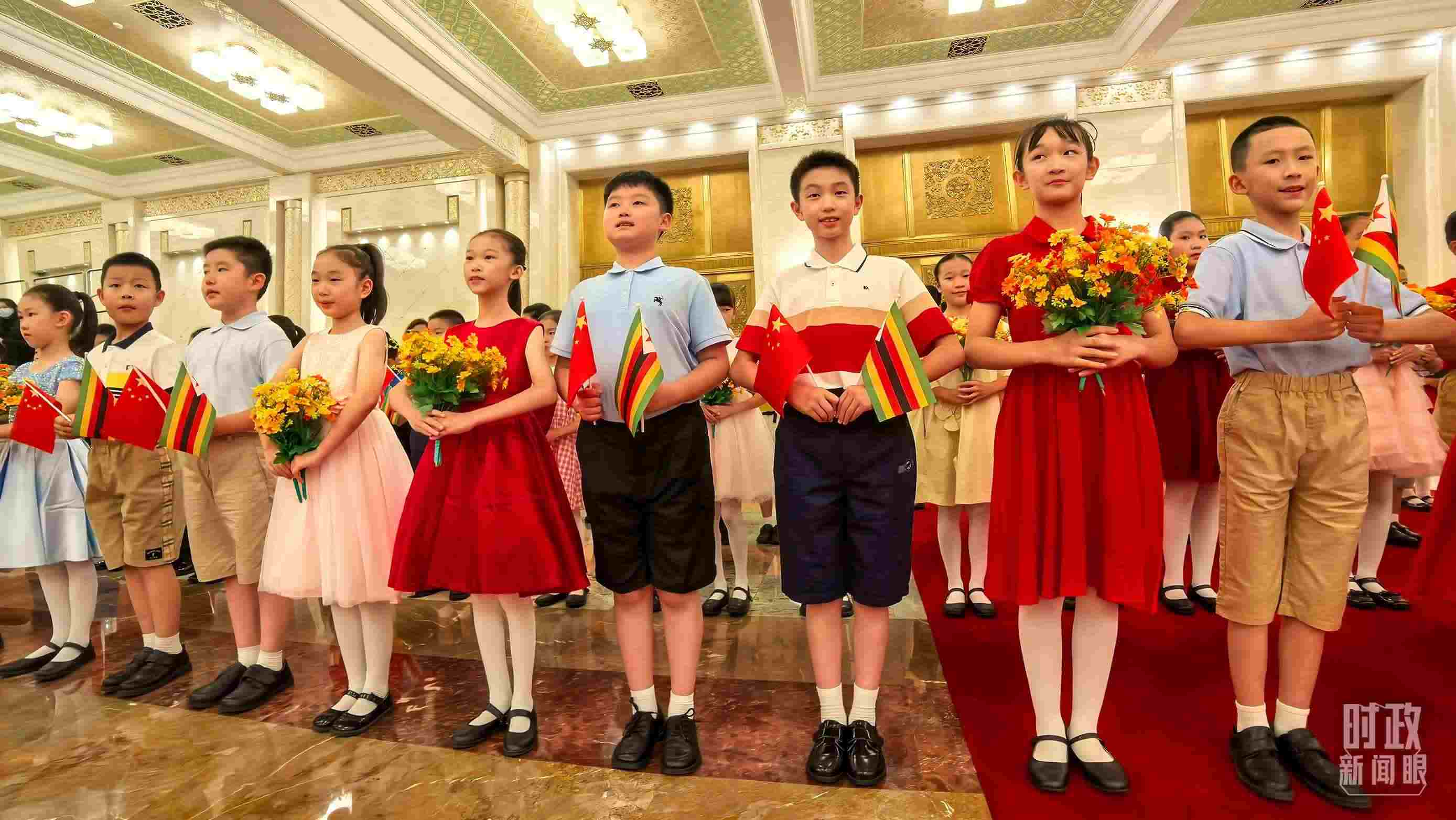 △現(xiàn)場歡迎津巴布韋總統(tǒng)訪華的青少年。（總臺央視記者鐘銳拍攝）