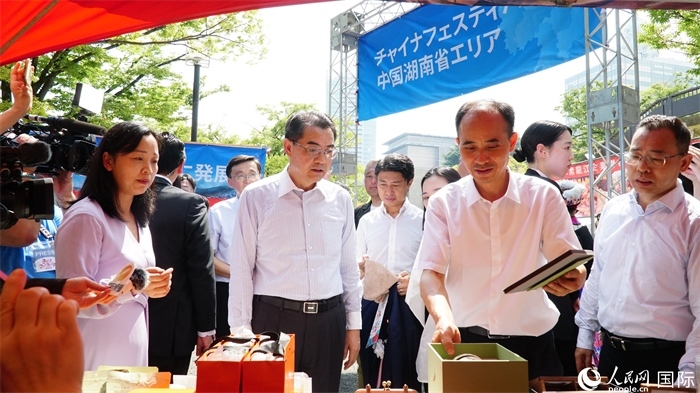 湖南展位工作人員向中國(guó)駐日本大使吳江浩介紹特色文創(chuàng)產(chǎn)品。人民網(wǎng) 蔣曉辰攝