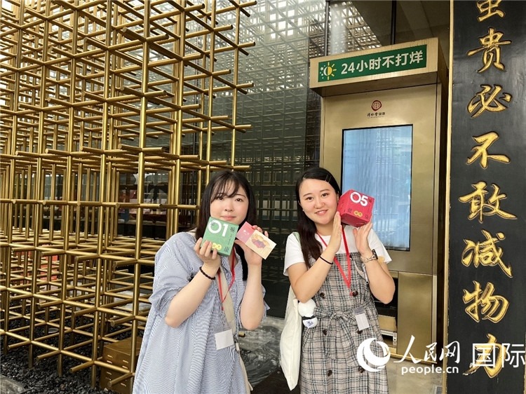 5. 代表團(tuán)團(tuán)員展示通過無人售藥機(jī)購買的盲盒。（人民網(wǎng)記者陳思 攝）