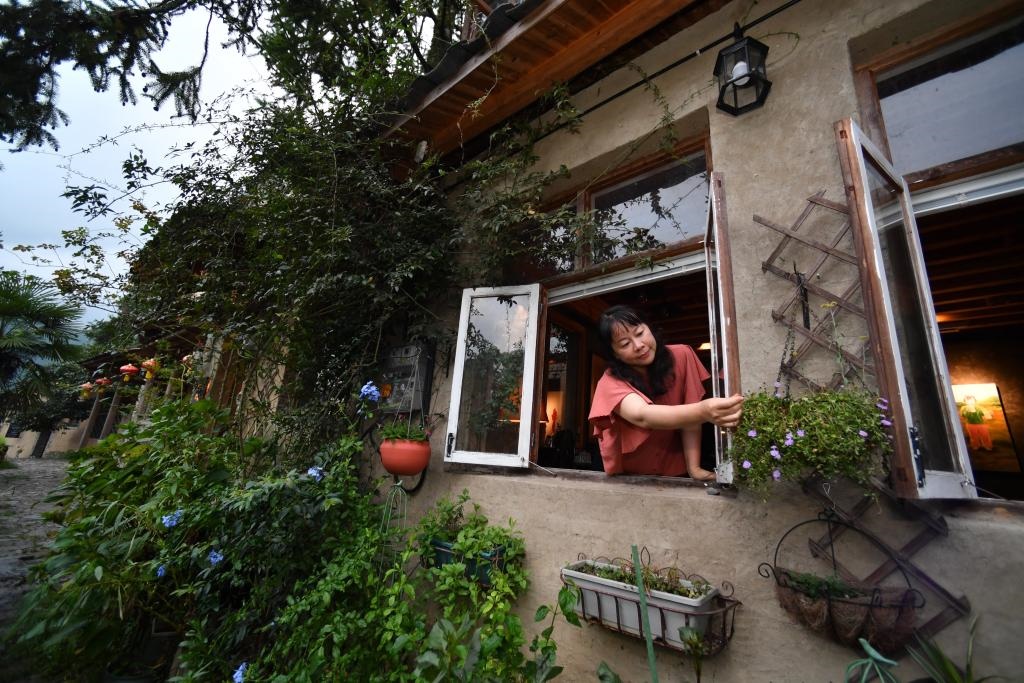 8月29日，在福建省屏南縣熙嶺鄉(xiāng)，龍?zhí)洞濉靶麓迕瘛泵泛暝诖蚶碜约航?jīng)營(yíng)的民宿外墻裝飾花盆。新華社記者姜克紅 攝