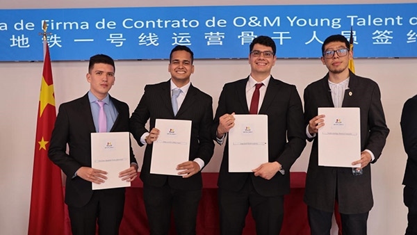 當?shù)貢r間9月13日，40名哥倫比亞青年與中企承建運營的波哥大地鐵一號線項目簽約，不久將前往中國進行為期15個月的專業(yè)地鐵知識培訓。圖為部分學員在簽約儀式上展示所簽的協(xié)議。 波哥大地鐵一號線項目供圖