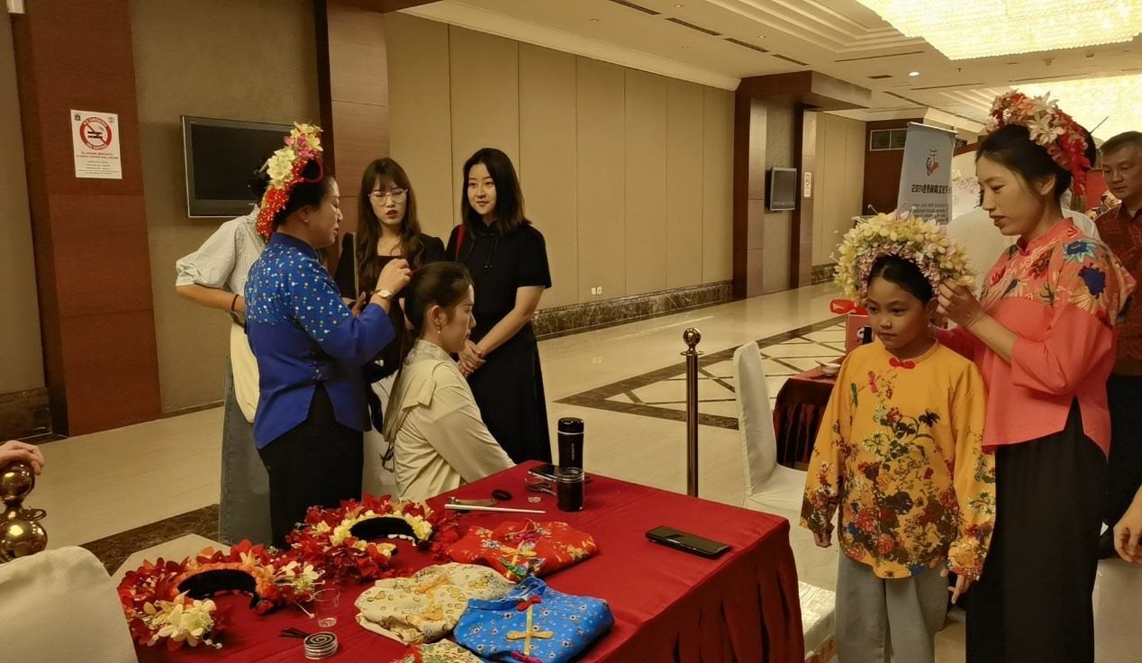 阿拉扎大學(xué)孔子學(xué)院志愿者老師向傳承人學(xué)習(xí)簪花圍。阿拉扎大學(xué)孔子學(xué)院供圖