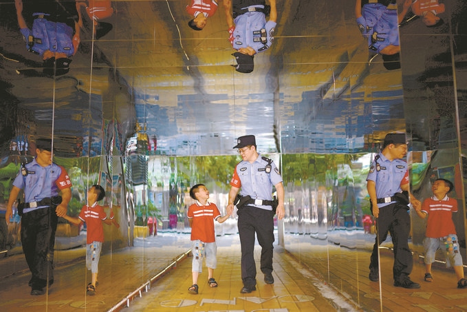 ?7月16日，重慶市公安局江北區(qū)分局一名民警在巡邏途中遇到一個獨自玩耍的小男孩，民警將其送回家。王洪平攝