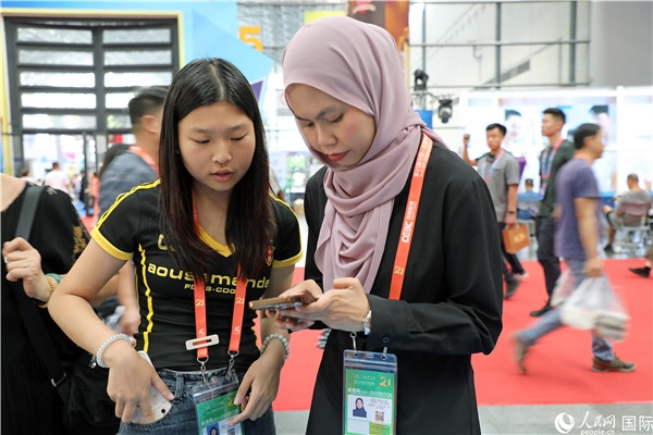 東博會(huì)現(xiàn)場，馬來西亞展商在同中方工作人員交談。人民網(wǎng)記者 趙益普攝