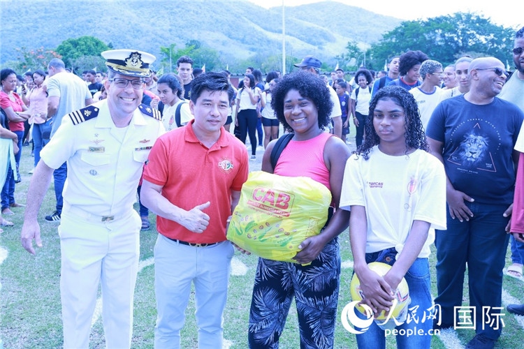 巴西中國浙江商會會長鄭俠茂向巴西貧困社區(qū)兒童及家庭捐贈基礎食品籃子和足球。人民網記者陳海琪 攝