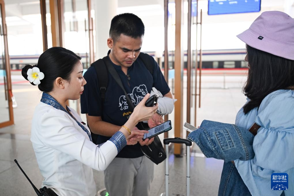 10月12日，在老撾萬象中老鐵路萬象站，工作人員檢驗乘客車票。新華社記者 程一恒 攝