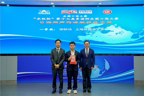 北京第二外國(guó)語(yǔ)學(xué)院副院長(zhǎng)鄭承軍（右一）、永旺中國(guó)投資有限公司集團(tuán)管理總部總經(jīng)理稻垣浩司（左一）為獲得日語(yǔ)同傳組一等獎(jiǎng)的上海外國(guó)語(yǔ)大學(xué)的張欽沅頒獎(jiǎng)。主辦方供圖