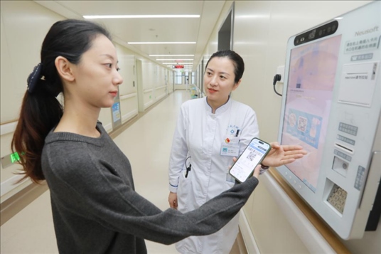 醫(yī)護人員引導患者在自助機前辦理自助入院手續(xù)。圖片來源：山東第一醫(yī)科大學第二附屬醫(yī)院