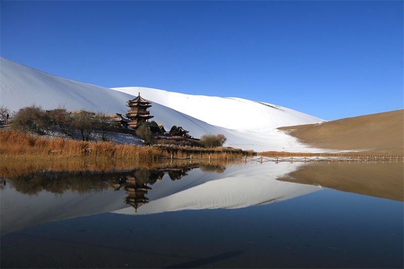 鳴沙山月牙泉景區(qū)雪景。敦煌市委宣傳部供圖，張曉亮攝