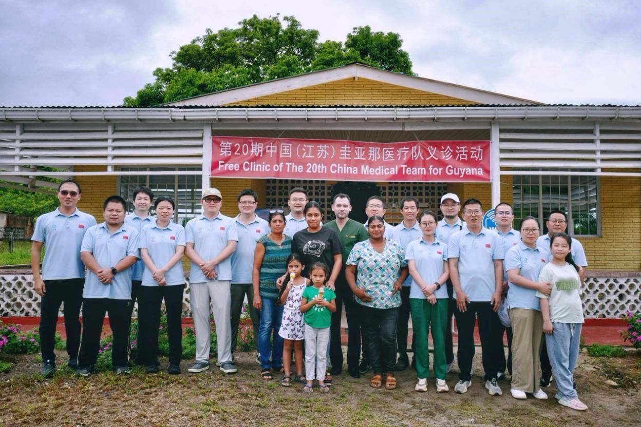 第20期中國（江蘇）援圭亞那醫(yī)療隊在圭偏遠的林登高速社區(qū)開展義診后，與部分當?shù)鼐用窈嫌啊?中國援圭醫(yī)療隊供圖