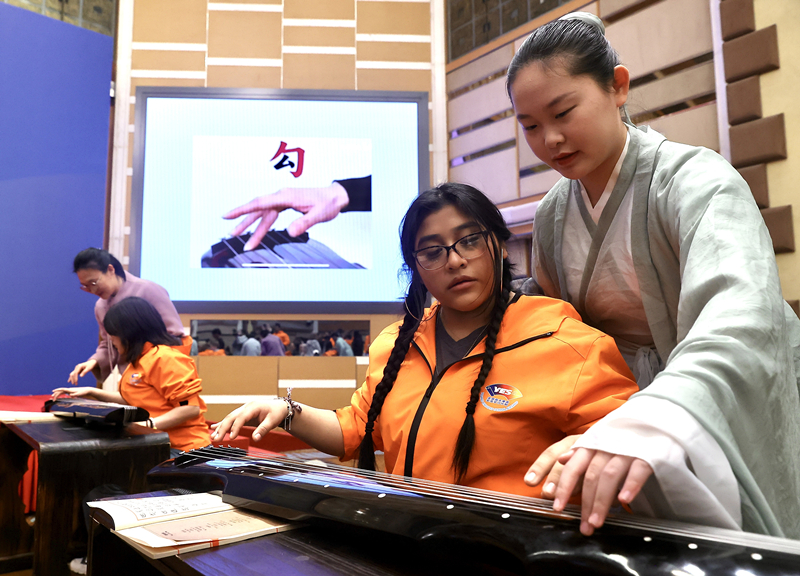 2024年3月20日，美國(guó)華盛頓州中學(xué)生代表團(tuán)北京大學(xué)交流活動(dòng)在北京大學(xué)英杰交流中心舉行。圖為來(lái)自華盛頓州的中學(xué)生體驗(yàn)古琴。