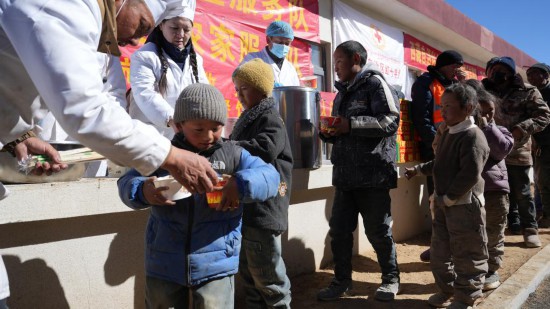 1月14日，廚師們正在給前來(lái)用餐的小朋友們打飯。新華社記者 邱星翔 攝