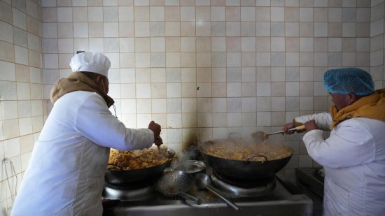 1月14日，服務(wù)隊(duì)的兩名廚師正在為村民們做午飯。新華社記者 邱星翔 攝