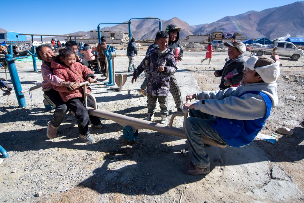 1月11日，在定日縣措果鄉(xiāng)塘仁村安置點(diǎn)，西藏星光社會(huì)工作服務(wù)中心志愿者和孩子們一起玩耍，進(jìn)行災(zāi)后心理疏導(dǎo)。人民網(wǎng)記者 翁奇羽攝