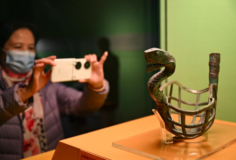 1月14日，觀眾在上海博物館蛇年迎春展拍攝展品蛇綱網(wǎng)狀銅器。新華社發(fā)（陳浩明攝）