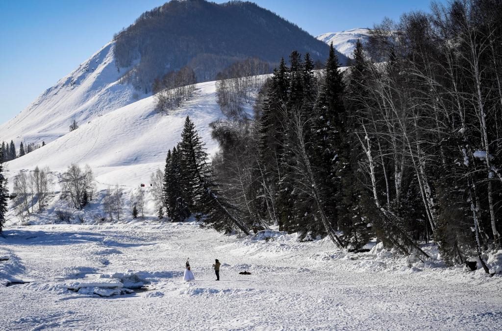 2024年2月5日，兩名游客在新疆阿勒泰地區(qū)布爾津縣禾木村拍照。新華社記者 馬鍇 攝