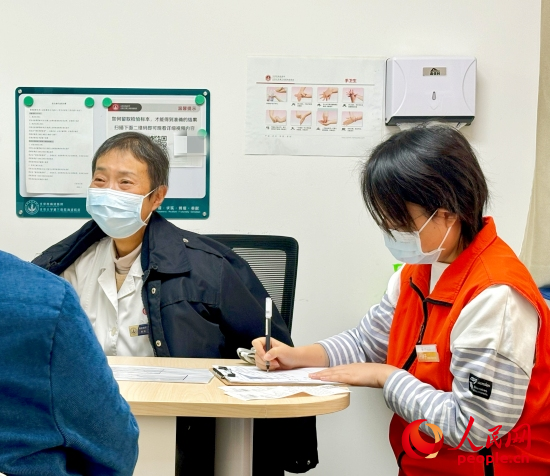 秦苑（中）接診患者。人民網(wǎng)記者 金慧慧攝