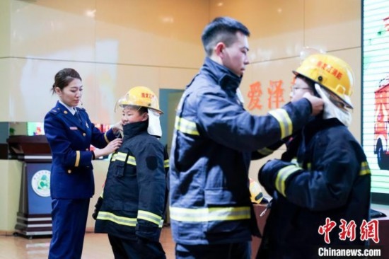 圖為學(xué)生們現(xiàn)場(chǎng)穿戴消防頭盔和戰(zhàn)斗服。中新社記者 趙宇航 攝