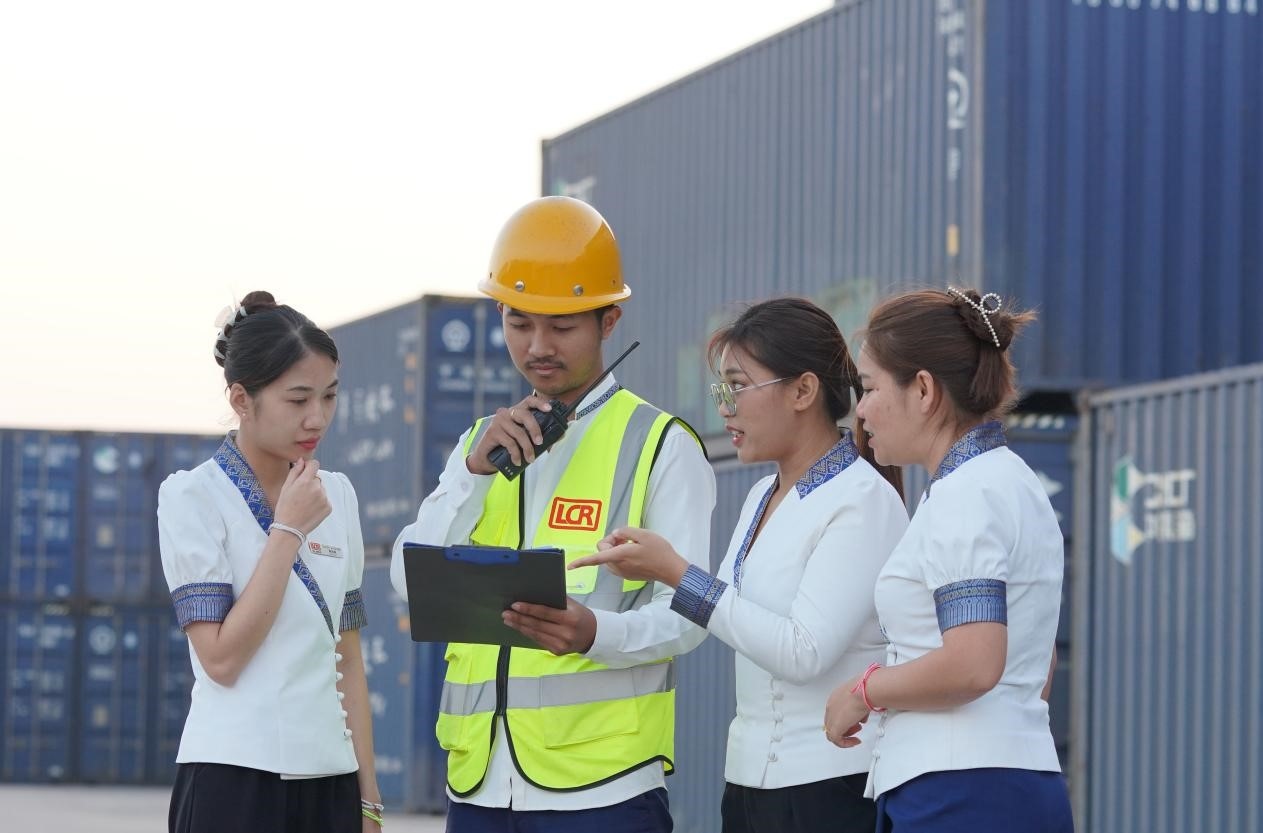 萬象南站貨運(yùn)值班員陳尼啦（左一）與同事在一起討論工作。老中鐵路有限公司供圖