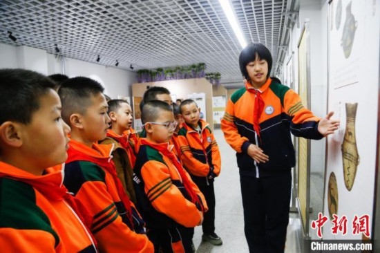 圖為學(xué)生通過展板了解出土于青海省海東市樂都區(qū)的辛店文化文物鹿紋彩陶甕。中新社記者 馬銘言 攝