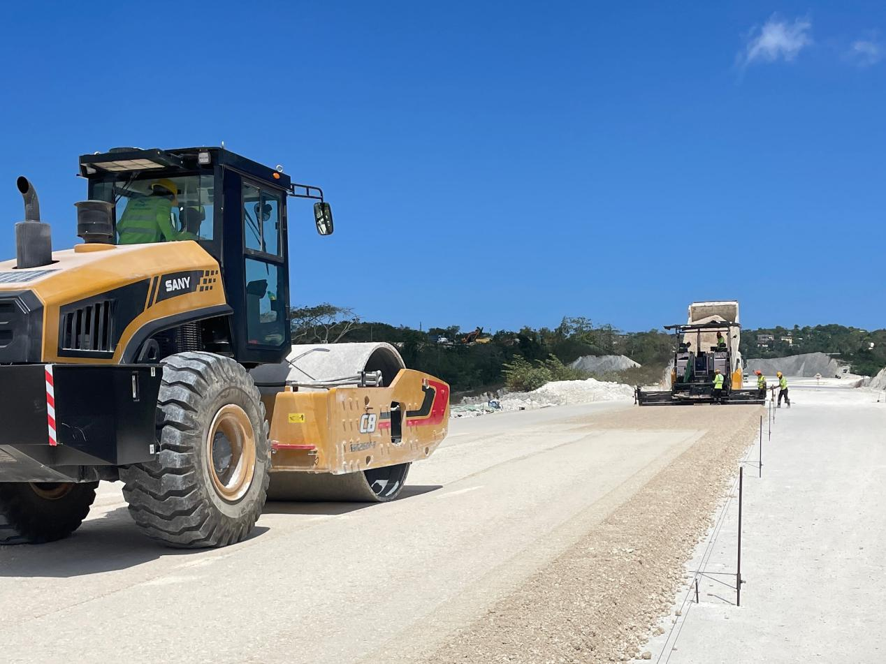 圖為中企承建的牙買加蒙特哥貝繞城路項(xiàng)目基層試驗(yàn)段正在進(jìn)行攤鋪和碾壓施工，相關(guān)施工工作已于日前順利完成。中國港灣美洲區(qū)域公司供圖