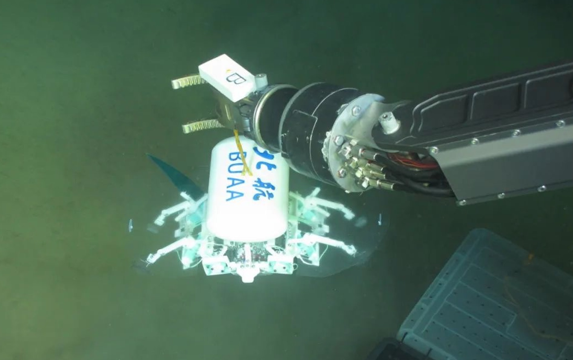 科研人員利用機(jī)械臂將北航深海小型機(jī)器人投于馬里亞納海溝。校方供圖