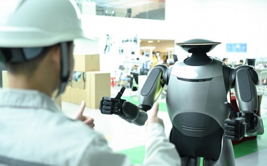 在廣汽研究院，人形機器人團隊的周仁義在演示GoMate機器人互動功能（新華社記者 鄧華 攝）