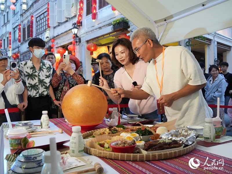 嘉賓品嘗海南傳統(tǒng)美食“煎堆”。人民網(wǎng)記者 張力洋攝