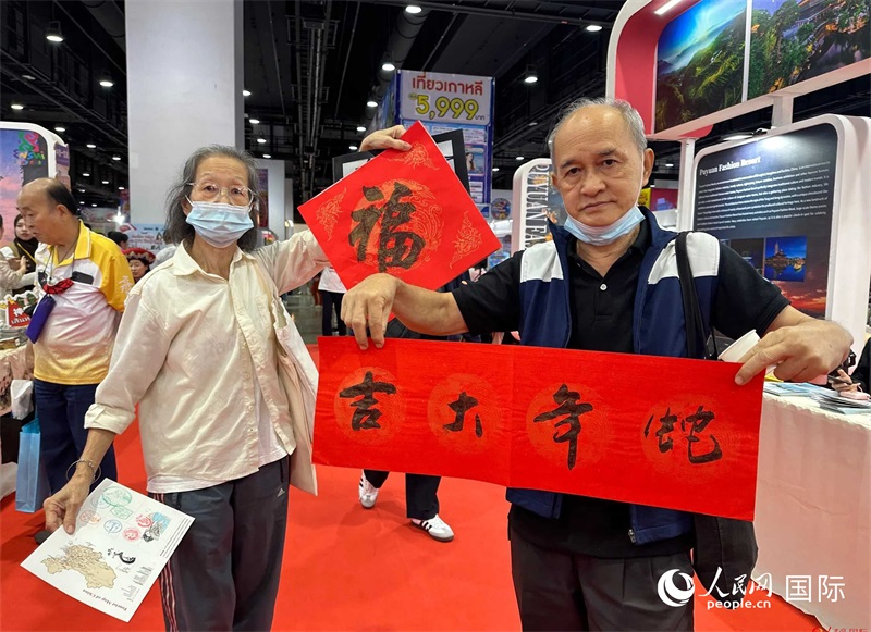 2025蛇年春節(jié)，泰國市民展示他們領(lǐng)到的華人手寫春聯(lián)。人民網(wǎng)記者 簡承淵攝