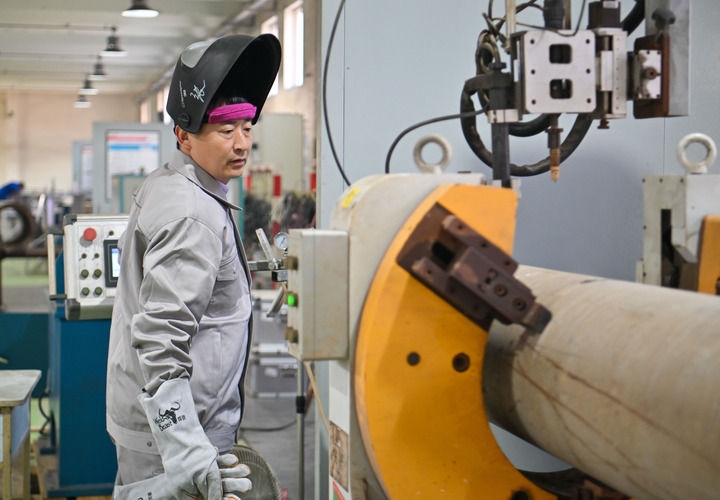 在中石化第四建設有限公司工匠學院，全國人大代表、中石化第四建設有限公司工匠學院焊接教練張振連操作自動焊機（2025年2月21日攝）。新華社記者 孫凡越 攝