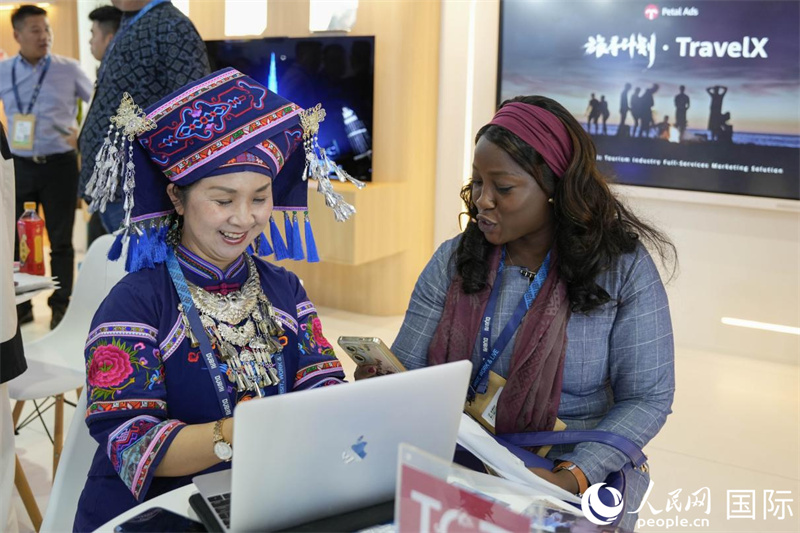 來(lái)自廣西的旅游業(yè)者同客戶交流。人民網(wǎng)塔里克·易卜拉欣攝