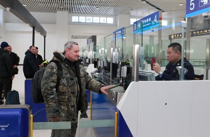 2024年12月10日，在黑河公路口岸旅檢大廳，黑河出入境邊防檢查站民警為首班次客車入境旅客辦理邊檢通關(guān)手續(xù)。當(dāng)日，中國黑河公路口岸—俄羅斯卡尼庫爾干公路口岸旅客運輸正式開通。新華社發(fā)（劉松攝）