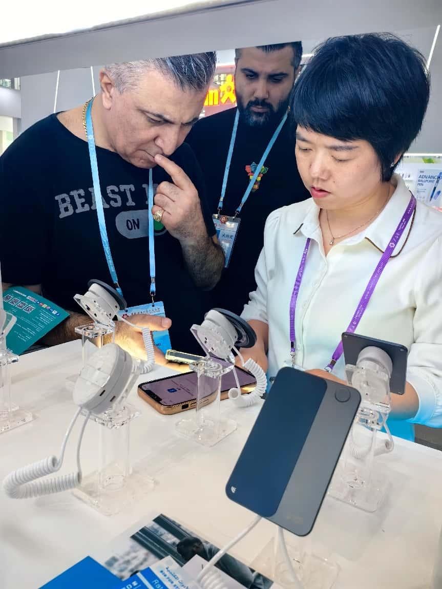 展臺(tái)工作人員向外商展示“AI TOP翻譯終端”。圖片來(lái)源：受訪者提供