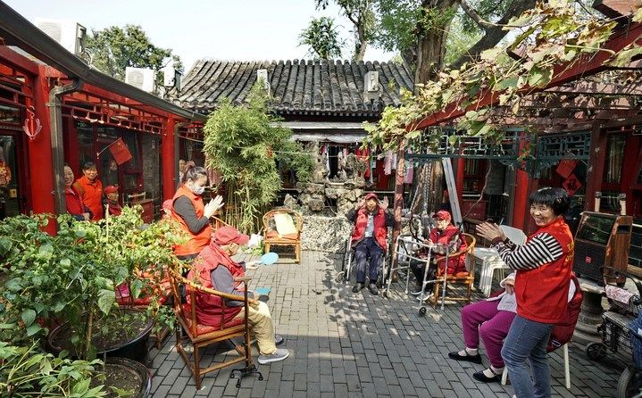 2024年10月12日，鐘樓灣胡同的老年人在社區(qū)內(nèi)的四合院養(yǎng)老驛站休閑。2017年起，北京市先后開展了兩輪背街小巷環(huán)境整治提升行動(dòng)，完整保留了中軸線生活建筑群的歷史信息，并根據(jù)居民的生活和居住方式進(jìn)行適配化的更新和改造，極大地改善了生活環(huán)境。2023年鐘樓灣胡同被評(píng)為“北京最美街巷”。