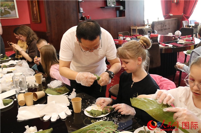 烏克蘭兒童學(xué)習(xí)體驗包粽子。人民網(wǎng)記者蔡子暢攝
